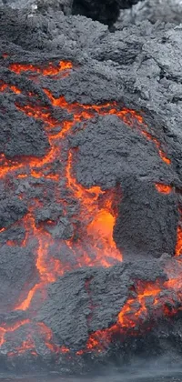 This phone live wallpaper showcases an intense, close-up view of a massive plume of lava rising out of dark waters