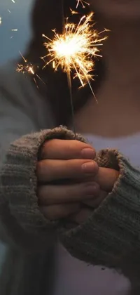 This gorgeous phone live wallpaper features an exquisite image of a woman holding a sparkler in her hands