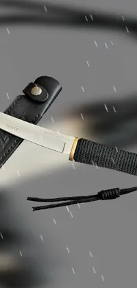 This live wallpaper features a close-up view of a sharp knife hung on a string against a dynamic stormy sky