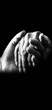This black and white live wallpaper features a heartwarming photo of two interlocked hands