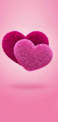 This phone live wallpaper features two fluffy, pink hearts floating in the air