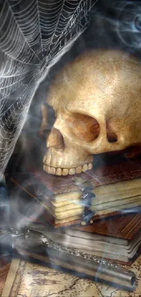 This live phone wallpaper features a haunting image of a skull resting on a stack of books, surrounded by the eerie fog of a gothic scene