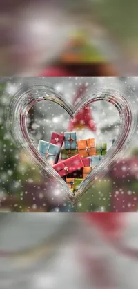 This stunning phone live wallpaper features a heart-shaped Christmas ornament adorned with presents in bright colors, perfect for adding a festive touch to your device