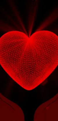 This phone live wallpaper features two hands holding a glowing red heart in a digital rendering by Jon Coffelt