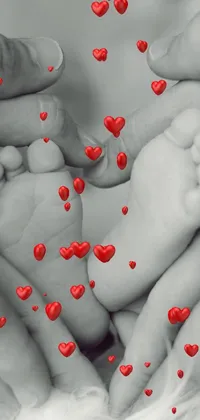 This black and white live wallpaper features a close-up of a baby's foot being held within an formed by the necks of a couple and their son