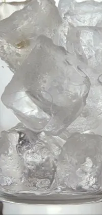 This stunning live wallpaper showcases a glass filled with ice, set on a table