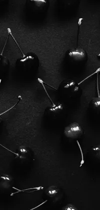 This phone live wallpaper features a stunning image of cherries on a table, with a black and white minimalist design