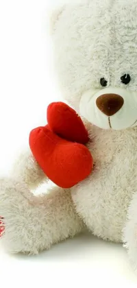 This adorable phone live wallpaper offers a heartwarming scene featuring a white teddy bear holding a red heart