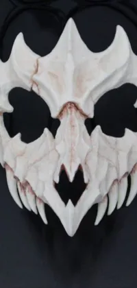 This phone live wallpaper showcases a detailed mask design on a black background