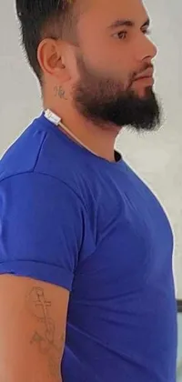 This phone live wallpaper features a man with a stylish beard sporting a blue shirt and a unique tattoo