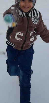 This live wallpaper features a lively winter scene of a young boy in the snow