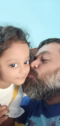 This live phone wallpaper features a heartwarming scene of a bearded man kissing a little girl on the cheek