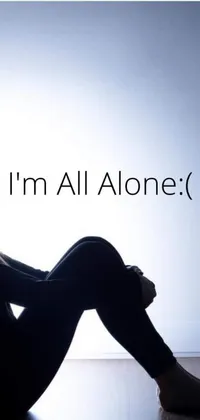 This stunning phone live wallpaper features an image of a lone female seated on the floor with the words "I'm all alone" in bold letters at the top