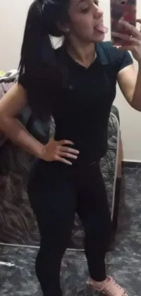 This live phone wallpaper showcases a confident woman flexing and posing in a stylish black uniform as she takes a selfie in a mirror