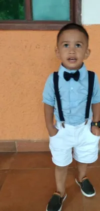 This engaging phone live wallpaper showcases an adorable little boy dressed in a stylish bow tie and suspenders