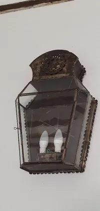 This vintage phone live wallpaper features a stunning 18th century folk art piece, showcasing a close-up of a painted metal and glass light fixture on a wall