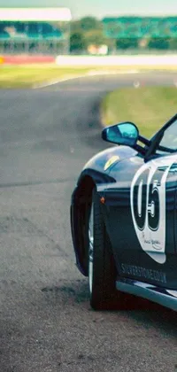 This phone live wallpaper features a sports car zooming along a race track