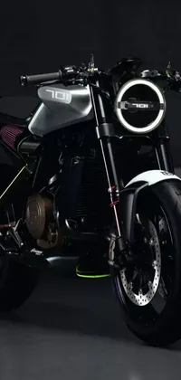 This phone live wallpaper depicts a sleek black motorcycle parked in a dark room with a white and yellow light cast on the front