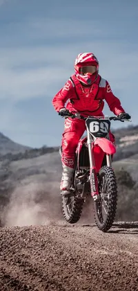 Looking for a live wallpaper that captures the excitement of dirt biking? Check out this thrilling design featuring a rider tearing down a dirt road on their crimson dirt bike