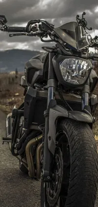 Introducing a fantastic phone live wallpaper featuring a photorealistic image of a motorcycle parked on a rugged road