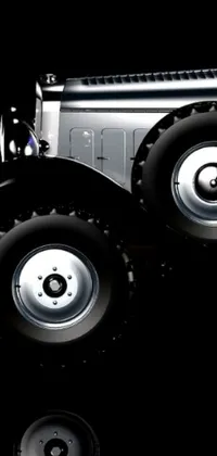 This stunning live phone wallpaper showcases a silver toy truck on a reflective surface, with black wheel rims and digital art featuring metallic blues and greens