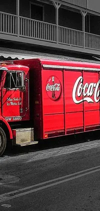 This phone live wallpaper features a vibrant red Coca Cola truck parked on a street in front of a brick building with balconies
