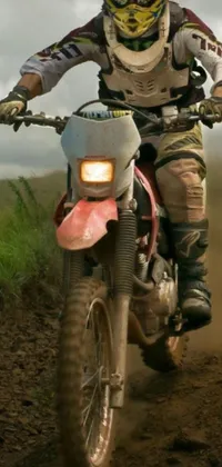 This dynamic phone wallpaper features a zoomed-in view of a dirt biking experience on a muddy terrain
