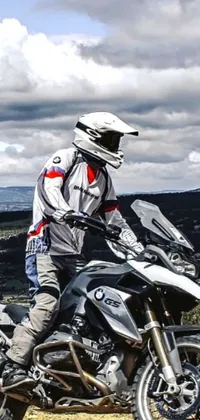 Looking for a stunning motorcycle-themed live wallpaper for your phone? Check out this impressive Instagram photo of someone donning an advanced technology flight suit, riding a BMW motorbike on a dusty, dirt road! Perfect for adventure and tech lovers, the gray suit and bike stand out amidst the muted tones of the surrounding landscape