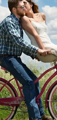Elevate your phone's home screen with a stunning live wallpaper of an amorous couple riding a bike together in a lush grassy field