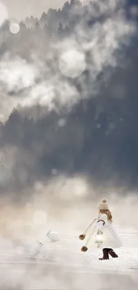This phone live wallpaper showcases a winter scenery with a woman walking across a snow covered field wearing a white gown and veil while carrying a white bouquet