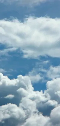 This phone live wallpaper showcases a large jetliner flying high above soft and billowy cumulus clouds set against a vibrant blue sky