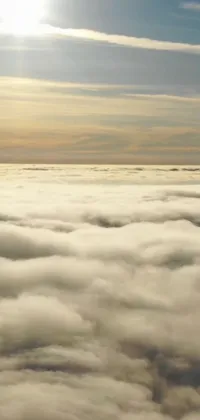 This phone live wallpaper showcases a stunning aerial view of a plane flying high above the clouds