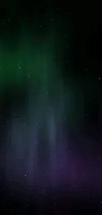 Enjoy the stunning beauty of the aurora borealis with this green and purple space wallpaper for iPhone 15