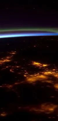 This phone live wallpaper showcases a breathtaking view of Earth from space at night, highlighting the stunning natural lights and colors across the planet