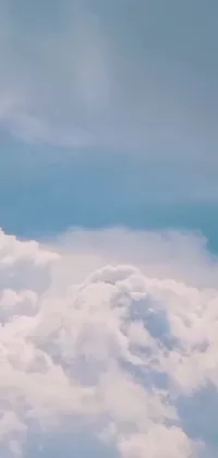 This live wallpaper captures the dreamy aesthetic of a jetliner cruising through a blue sky with fluffy white clouds