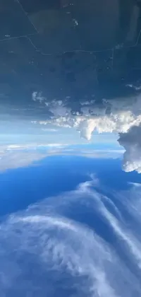 This phone live wallpaper showcases a breathtaking view of the sky and clouds, seen from the window of an airplane
