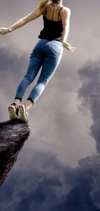 This phone live wallpaper showcases a captivating scene of a woman standing on a cliff and flying through the air