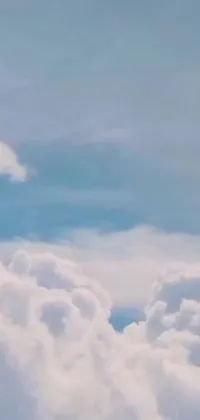 This phone live wallpaper captures a stunning yellow jetliner flying among the cotton candy clouds in a romantic blue sky