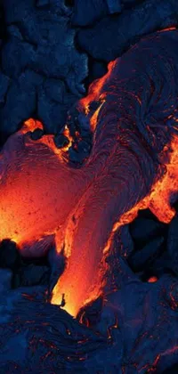 Transform your phone into a mesmerizing sight with this live wallpaper featuring lava flowing down the side of a mountain at night