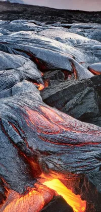 This phone live wallpaper features a captivating image of a lava field beside a beautiful sunset in the background