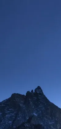 This live wallpaper features an exhilarating scene of a skier soaring through the air against a stunning blue night sky, set against the majestic ridge of Crib Goch