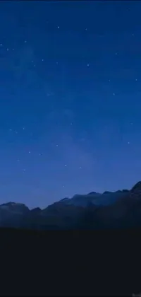 This phone live wallpaper showcases a serene nighttime landscape with imposing mountains in the distance