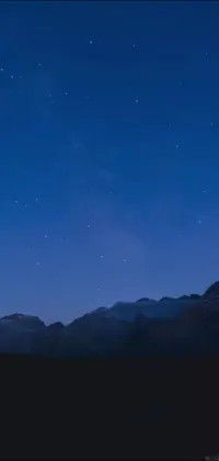 This phone live wallpaper boasts a stunning backdrop of a mountain range that's complemented by a cloudless night sky filled with twinkling stars