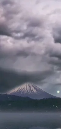 This dynamic live wallpaper showcases a serene body of water with a mountain backdrop, set against a dramatic thundercloud-filled sky