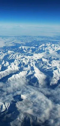 This phone live wallpaper showcases a stunning view of snow-capped mountains from an airplane window