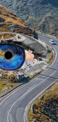 This unique live wallpaper captures a surrealistic painting of an eye hovering above a winding road amongst a majestic mountain pass