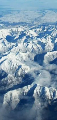 This live wallpaper showcases a breathtaking view of snow-capped mountains, as seen from an airplane window, providing a high-altitude perspective