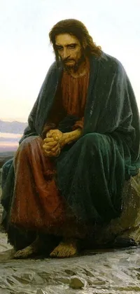 This mobile live wallpaper depicts a serene scene of Jesus Christ sitting on a rock with his hands clasped