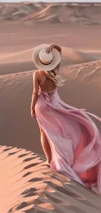 This live phone wallpaper features a woman standing atop a sand dune in a stunning photo with a tumblr aesthetic