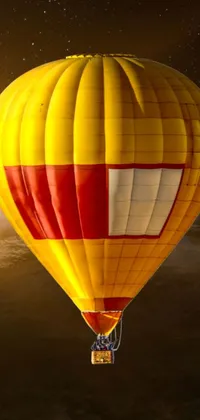 This phone live wallpaper portrays a hot air balloon flying high over the earth, boasting striking hues of yellow and red